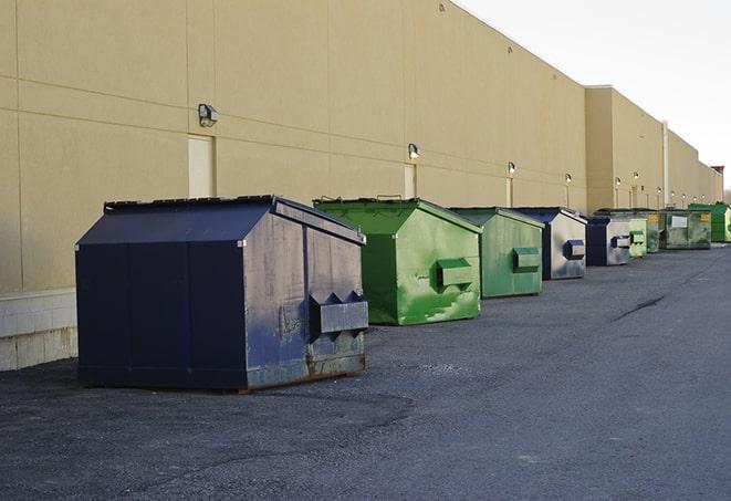 a construction worker moves construction materials near a dumpster in Clifford